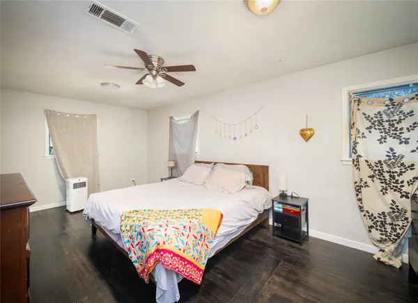 a bedroom with a bed and wooden floor