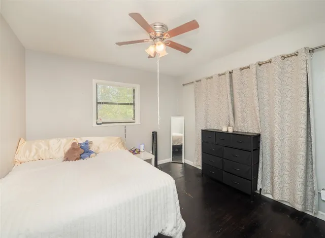 a bedroom with a bed and a chandelier fan