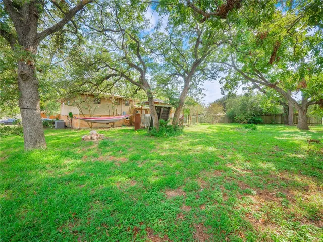 a view of green field with trees in the background