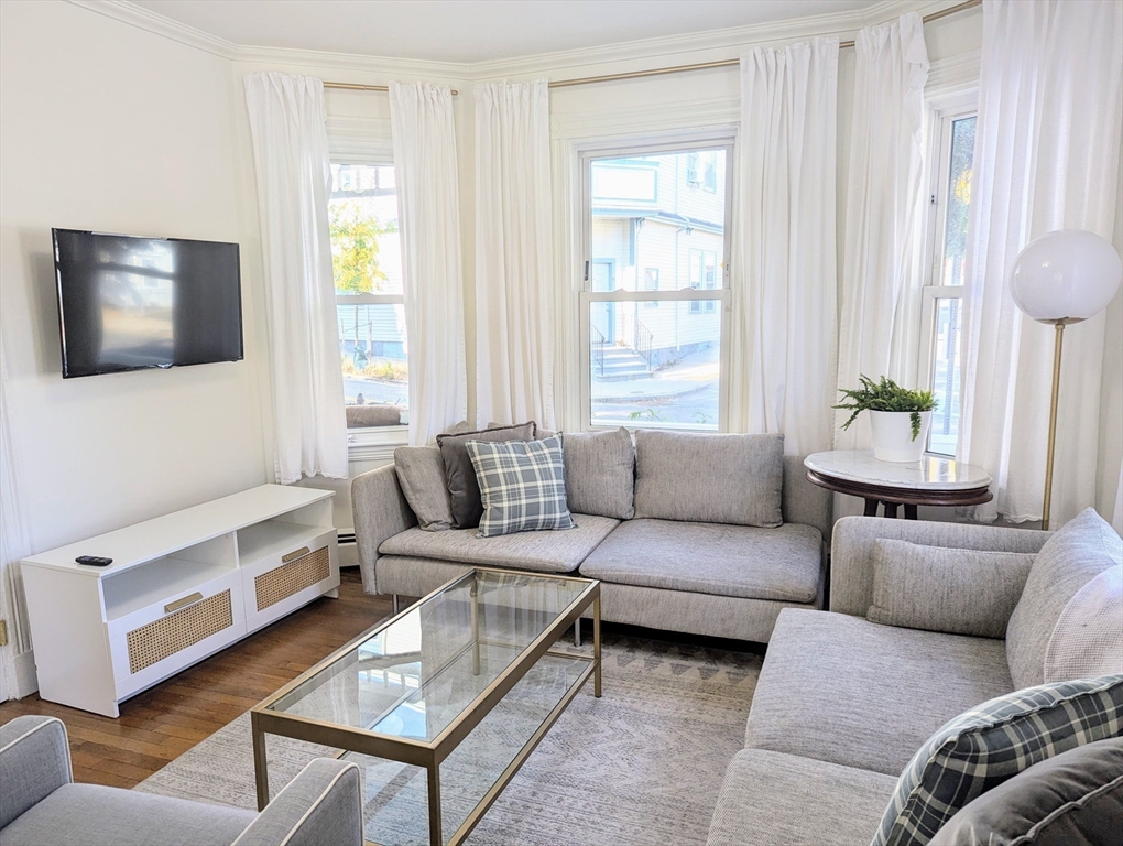 60 Day Street, Unit 1 Boston, MA 02130 - Photo 3 of 10 a living room with furniture and a flat screen tv