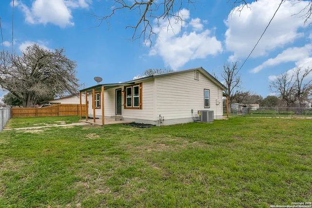 a view of a backyard with plants and large trees