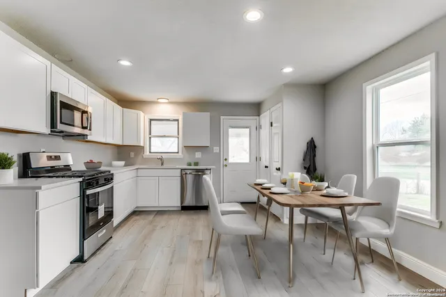 a kitchen with a table chairs stove and cabinets