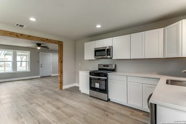 a kitchen with a sink a microwave and cabinets