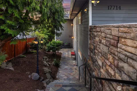 a backyard of a house with table and chairs potted plants