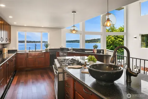 a kitchen with stainless steel appliances granite countertop a stove refrigerator and cabinets