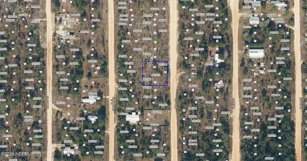 a view of a yard with trees in the background