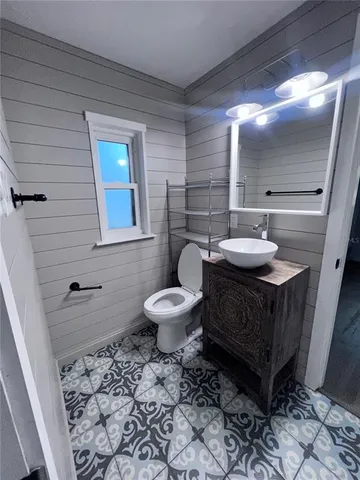 a bathroom with a toilet a sink and mirror