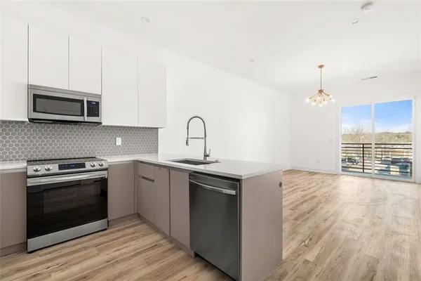 a kitchen with stainless steel appliances granite countertop a stove a sink and a microwave