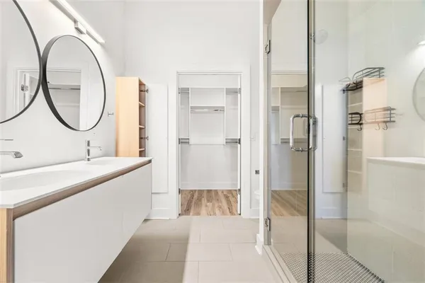 a bathroom with a granite countertop sink a mirror and a shower