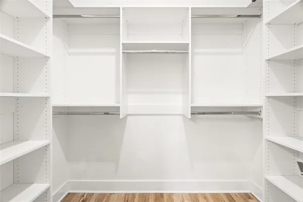 a view of walk in closet with empty racks