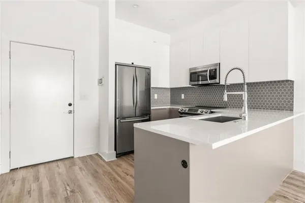 a kitchen with stainless steel appliances a sink and a refrigerator