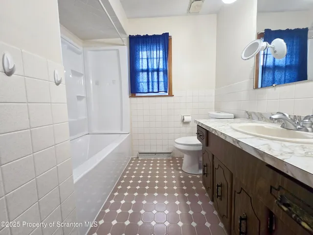 a bathroom with a sink a toilet a mirror and a shower