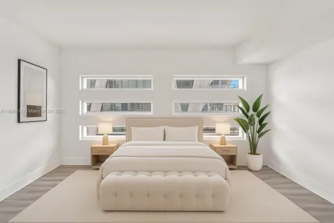 a bedroom with a large bed and a potted plant