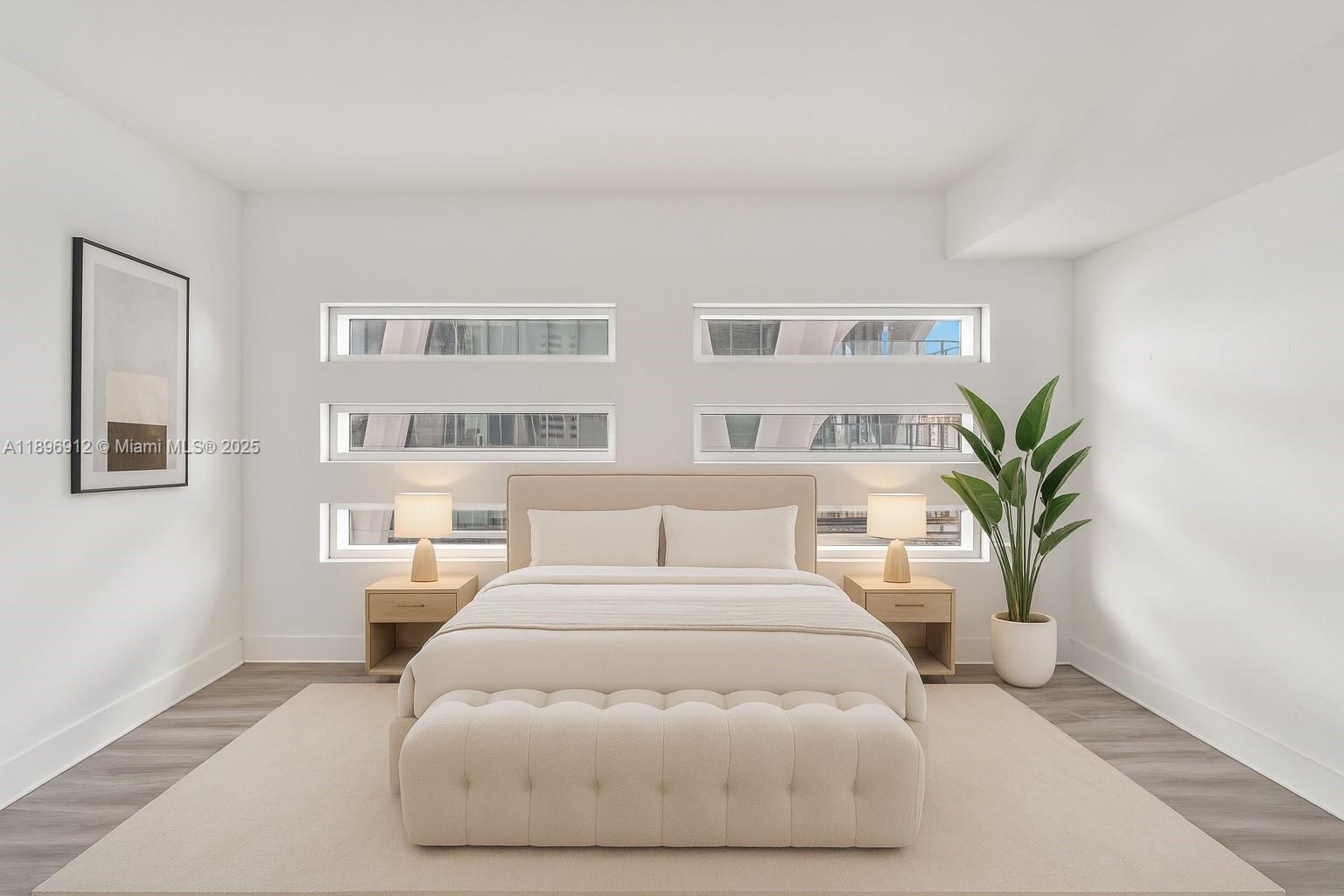 1040 Biscayne Boulevard, Unit 2402 Miami, FL 33132 - Photo 3 of 17 a bedroom with a large bed and a potted plant