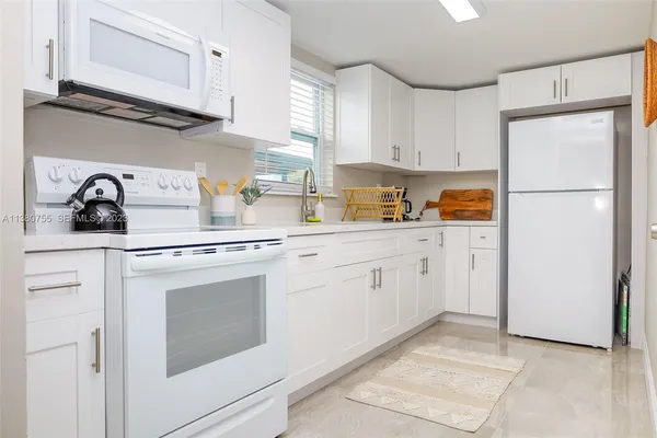 a kitchen with cabinets appliances and a dining table