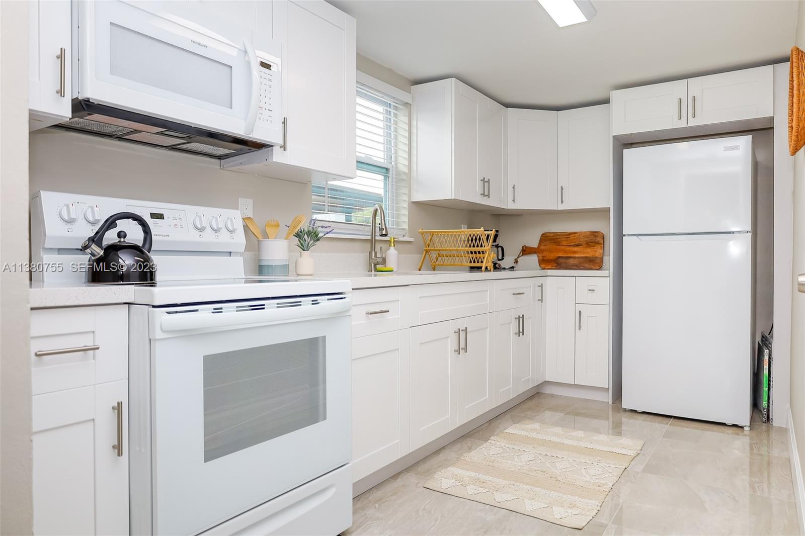 2761 Southwest 33rd Avenue, Unit 1 Miami, FL 33133 - Photo 12 of 46 a kitchen with stainless steel appliances white cabinets and a refrigerator