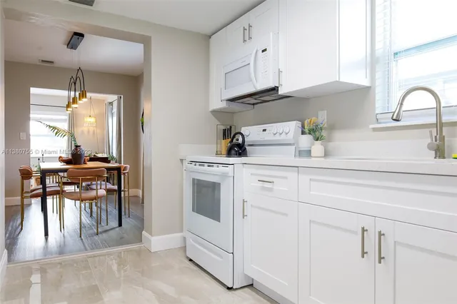 a kitchen with cabinets appliances and a dining table