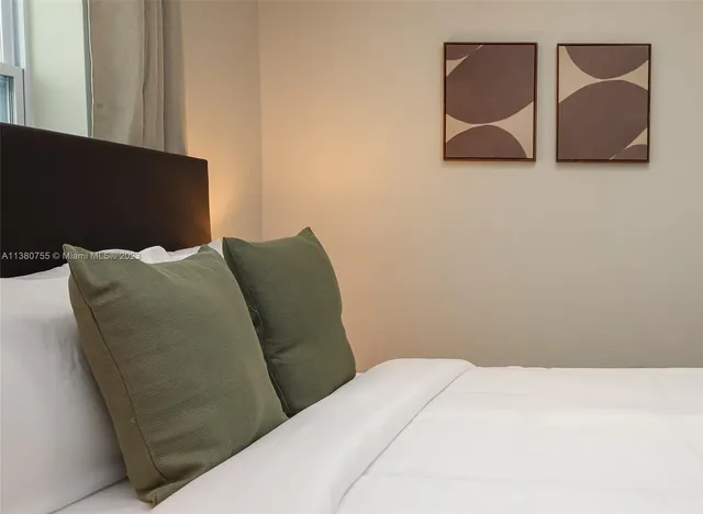 a bedroom with a bed and a wall painting