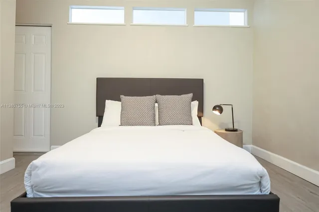 a large bed sitting in a bedroom next to a window
