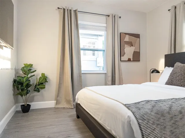 a bedroom with a bed and a potted plant