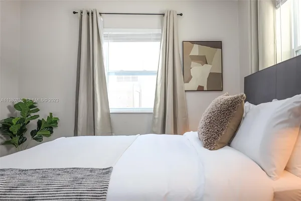 a large bed sitting in a bedroom next to a window