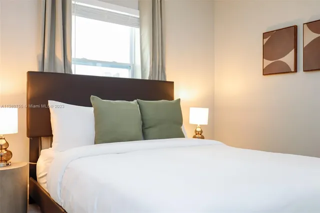 a large bed sitting in a bedroom next to a window