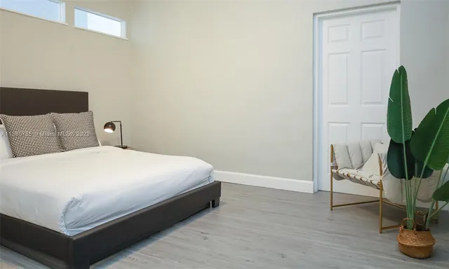 a bedroom with a bed and a potted plant