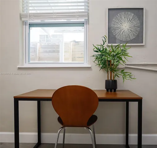 a view of a workspace room with furniture and a potted plant