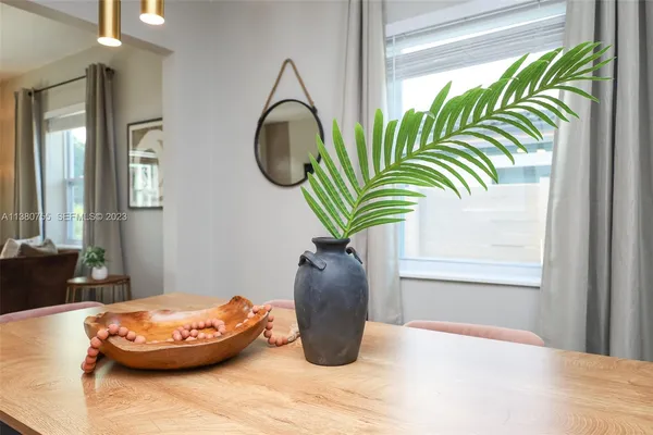 a dining room with furniture potted plants and wooden floor