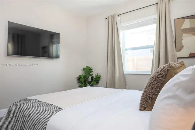 a bedroom with a bed and a flat screen tv