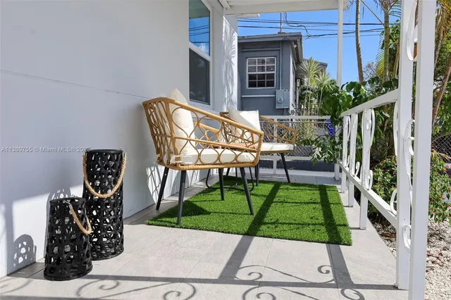 a view of two chairs and table in the patio