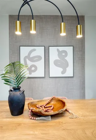 a dining room with furniture a potted plant and wooden floor