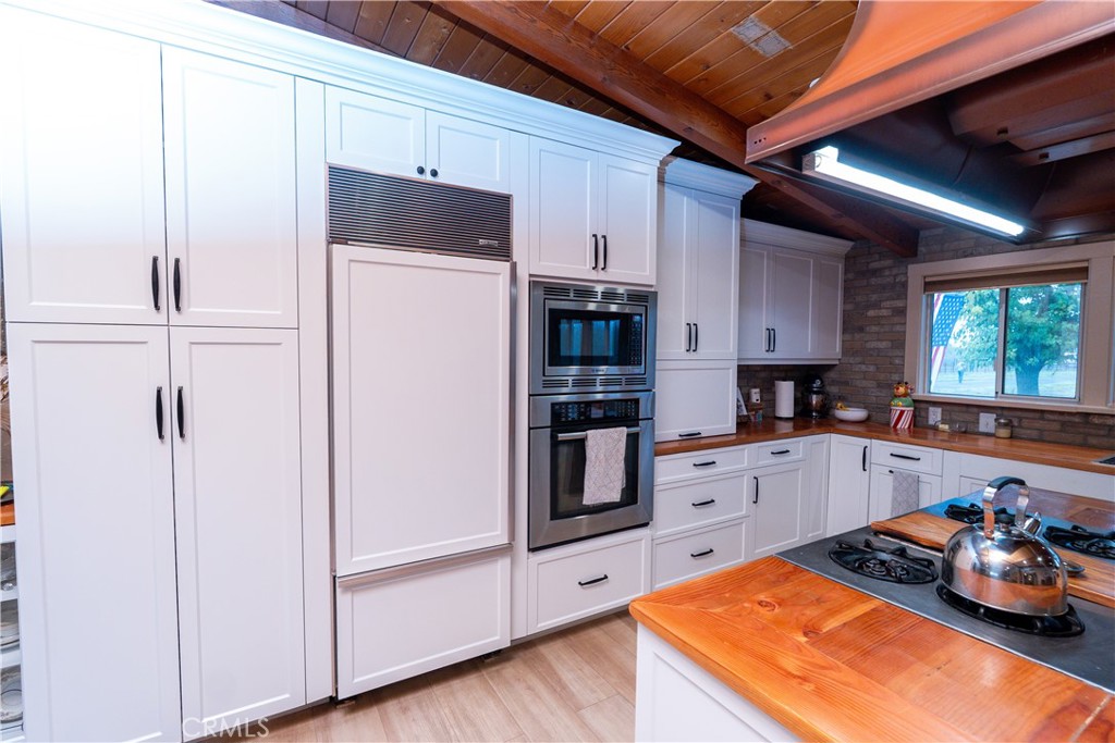 25565 Road 13 Chowchilla, CA 93610 - Photo 14 of 64 a kitchen with stainless steel appliances a refrigerator a sink and wooden floors