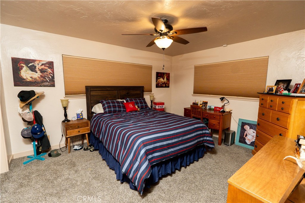 25565 Road 13 Chowchilla, CA 93610 - Photo 36 of 64 a bedroom with a bed and a flat tv screen on the dresser