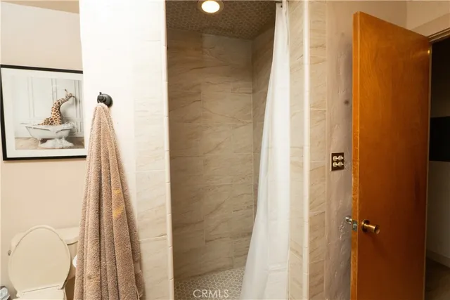 a bedroom with a bed and a chandelier with a flat tv screen