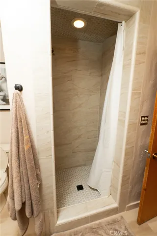 a spacious bedroom with a bed and a flat screen tv