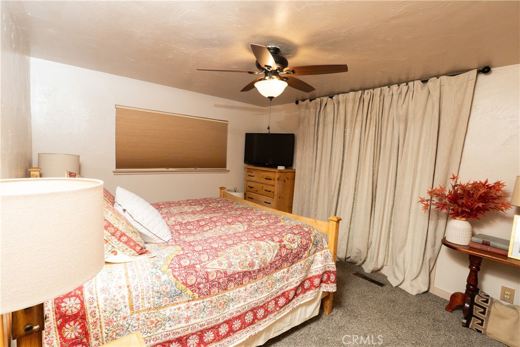 25565 Road 13 Chowchilla, CA 93610 - Photo 42 of 64 a bedroom with a bed and a chandelier with a flat tv screen