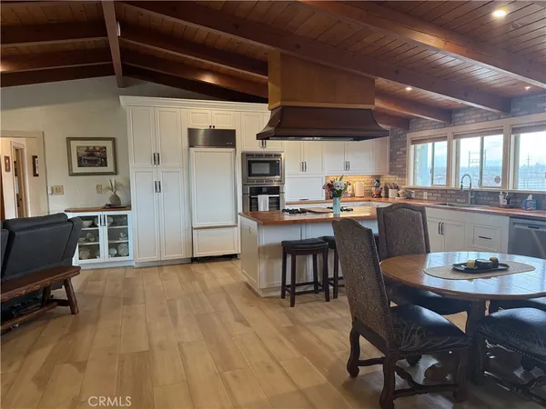 a kitchen with stainless steel appliances granite countertop table chairs sink and cabinets