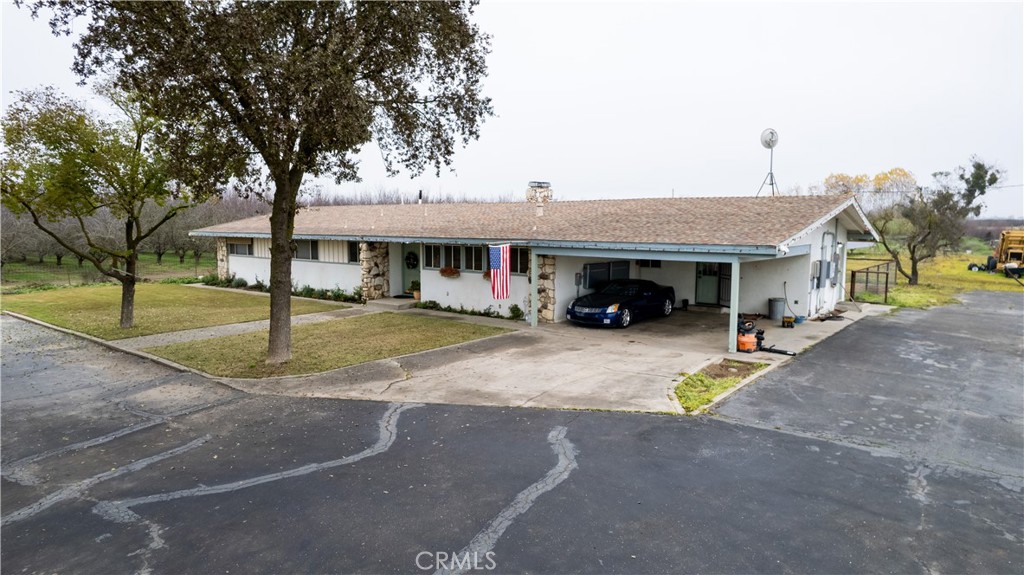 25565 Road 13 Chowchilla, CA 93610 - Photo 7 of 64 a view of a white house with a large space and a car parked in front of it