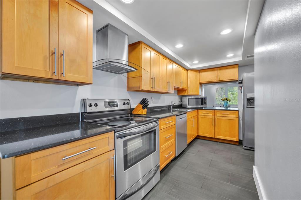 5377 Vineland Road, Unit 1D Orlando, FL 32811 - Photo 14 of 25 a kitchen with stainless steel appliances granite countertop sink stove and cabinets