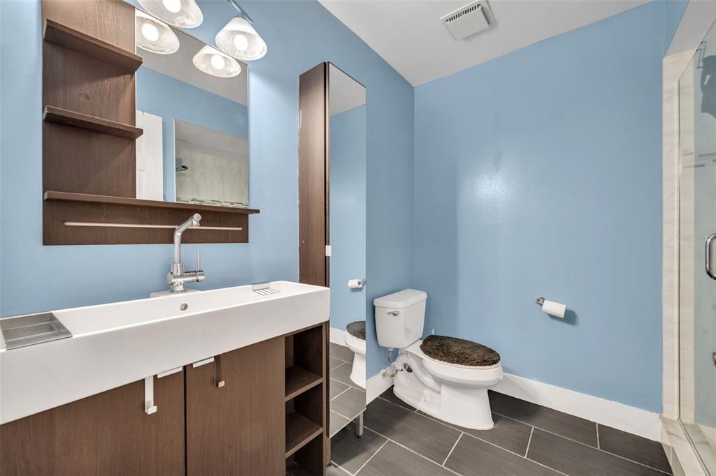 5377 Vineland Road, Unit 1D Orlando, FL 32811 - Photo 19 of 25 a bathroom with a sink a toilet a mirror and vanity