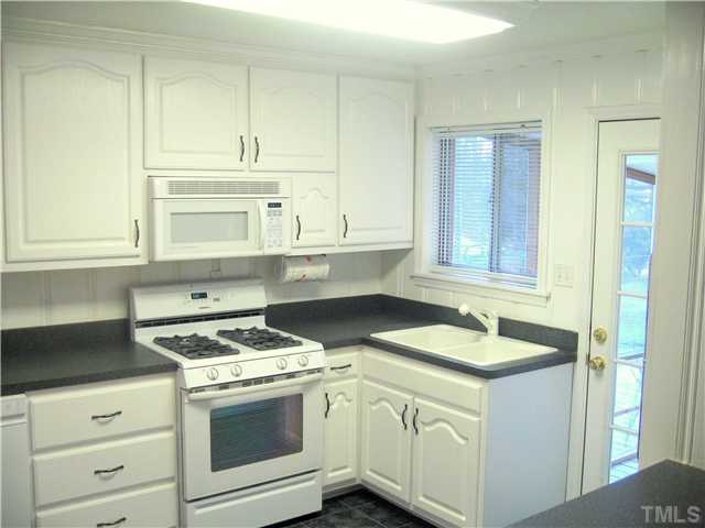 3519 Baugh Street Raleigh, NC 27604 - Photo 4 of 25 Light, bright kitchen with gas stove and convection oven. New face on cabinets only a few years old. All appliances remain for the new owner.