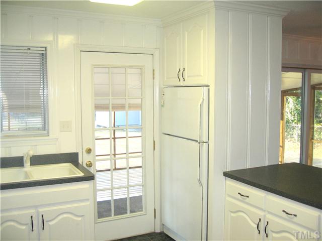 3519 Baugh Street Raleigh, NC 27604 - Photo 5 of 25 For the time period, this kitchen is very open. Notice the open countertop leading to the dining room on the right. The back door leads to the super-sized screen porch.
