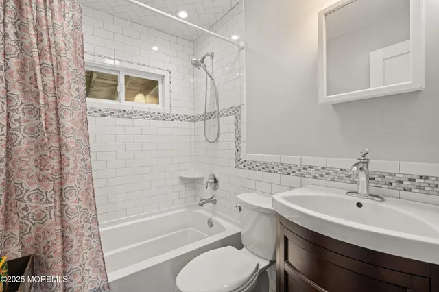 a bathroom with a bathtub shower sink vanity and toilet