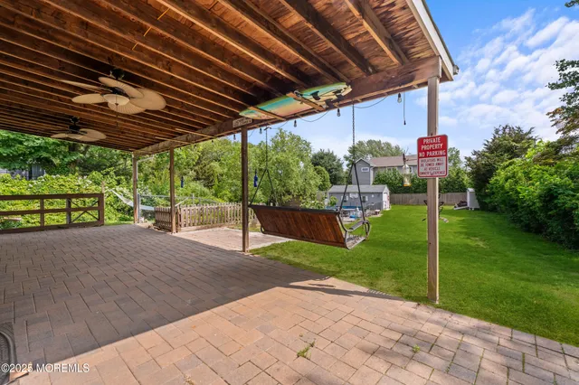 a view of a backyard with table and chairs under an umbrella with a small yard