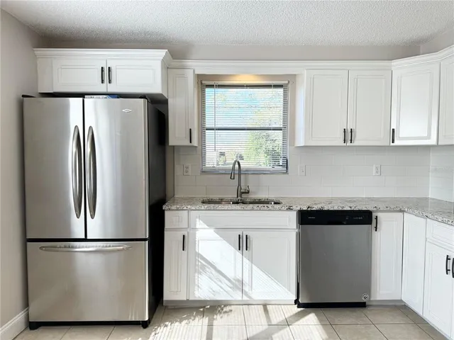 a kitchen with a refrigerator sink stove and cabinets