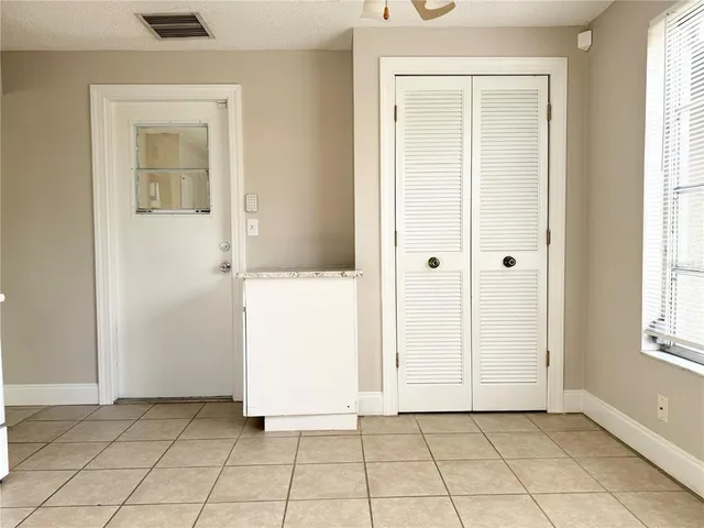 an empty room with windows and closet