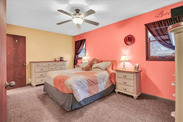 a bedroom with a bed a chandelier and a dresser