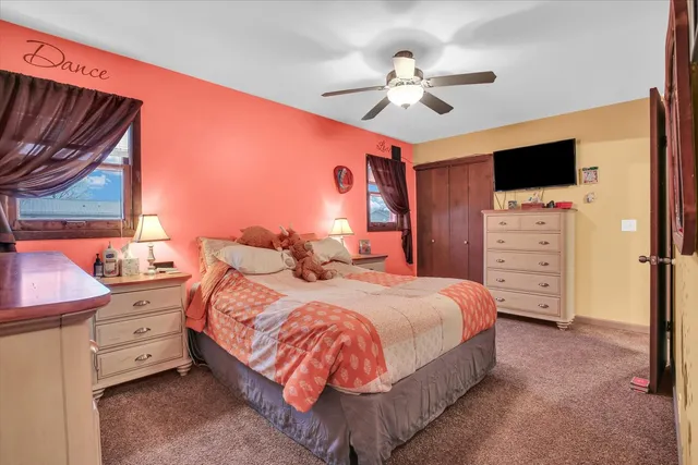 a bedroom with a bed ceiling fan and a window