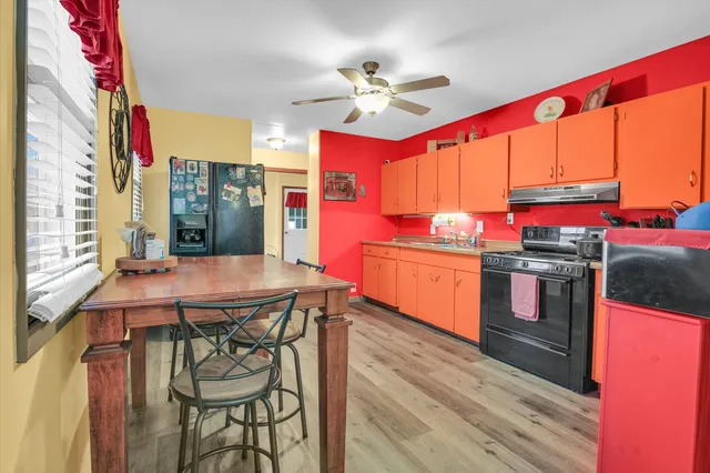 a kitchen with stainless steel appliances granite countertop a stove cabinets and wooden floor